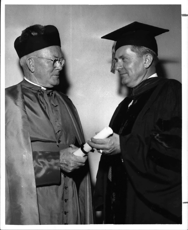 John G. Thompson receiving a Barry honorary degree from Monsignor William Barry